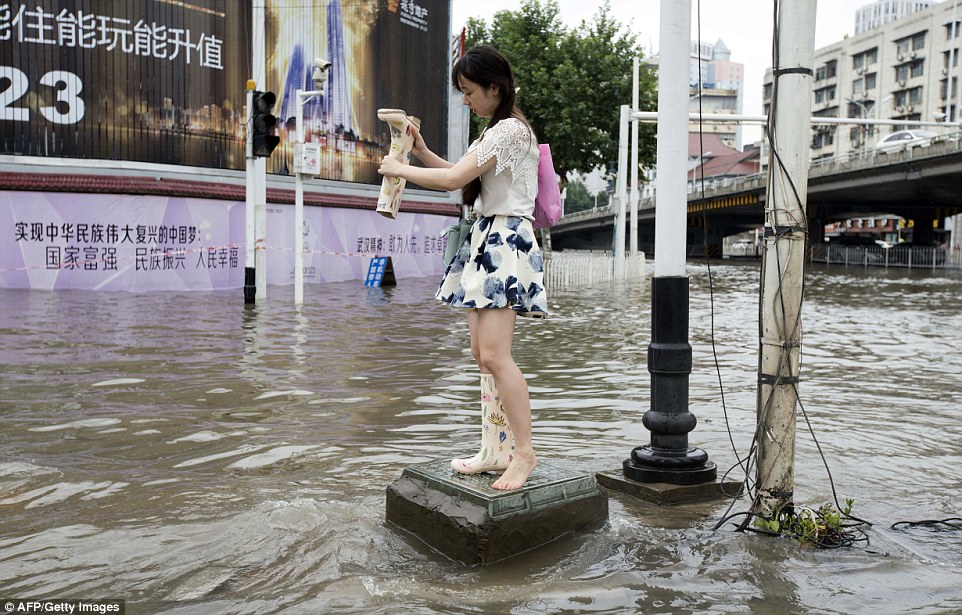 360993CF00000578-0-Lots_of_water_Woman_empties_water_from_her_boots_in_a_flooded_ar-a-4_1467965939084.jpg